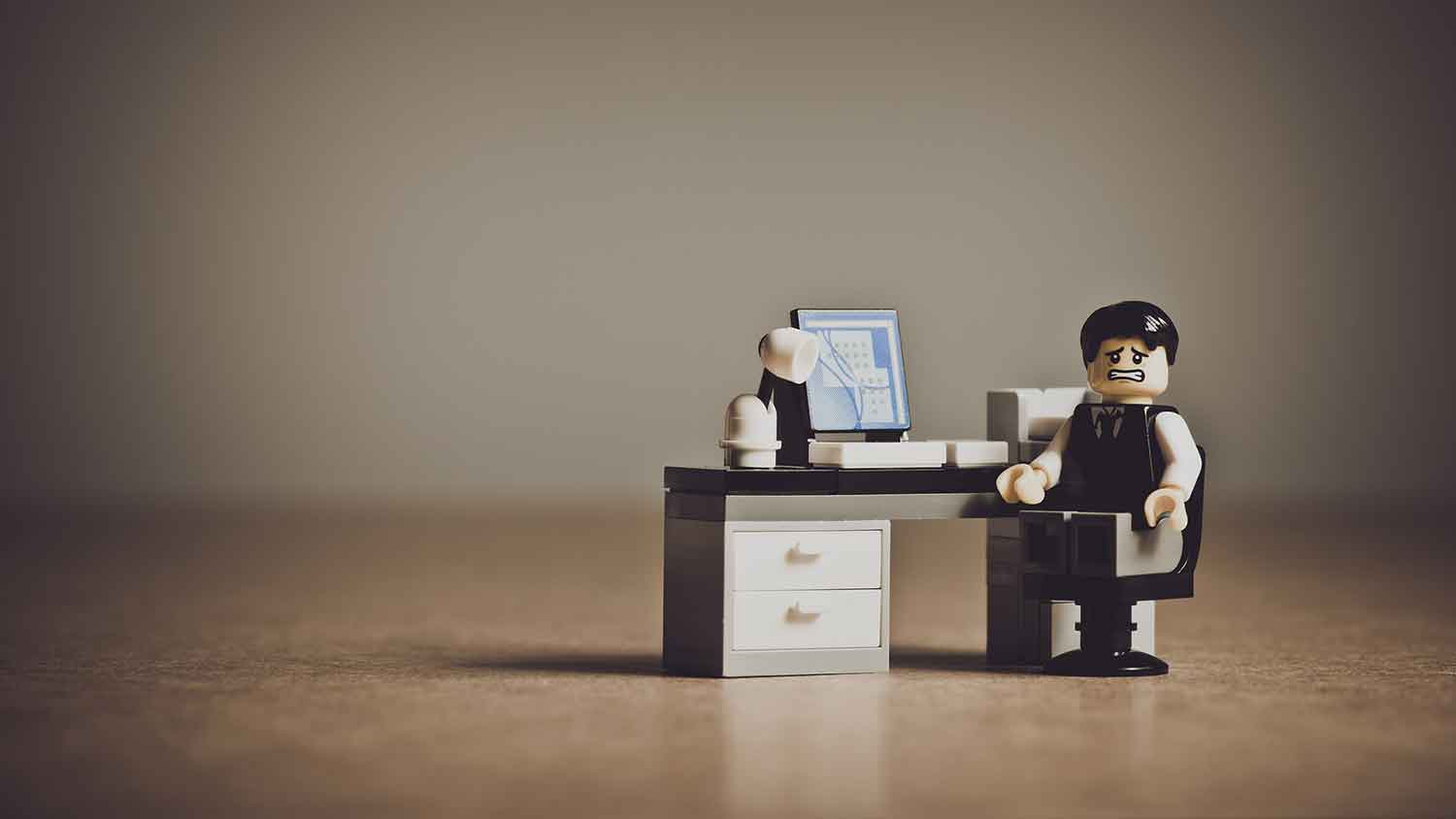 office worker made of lego in despair