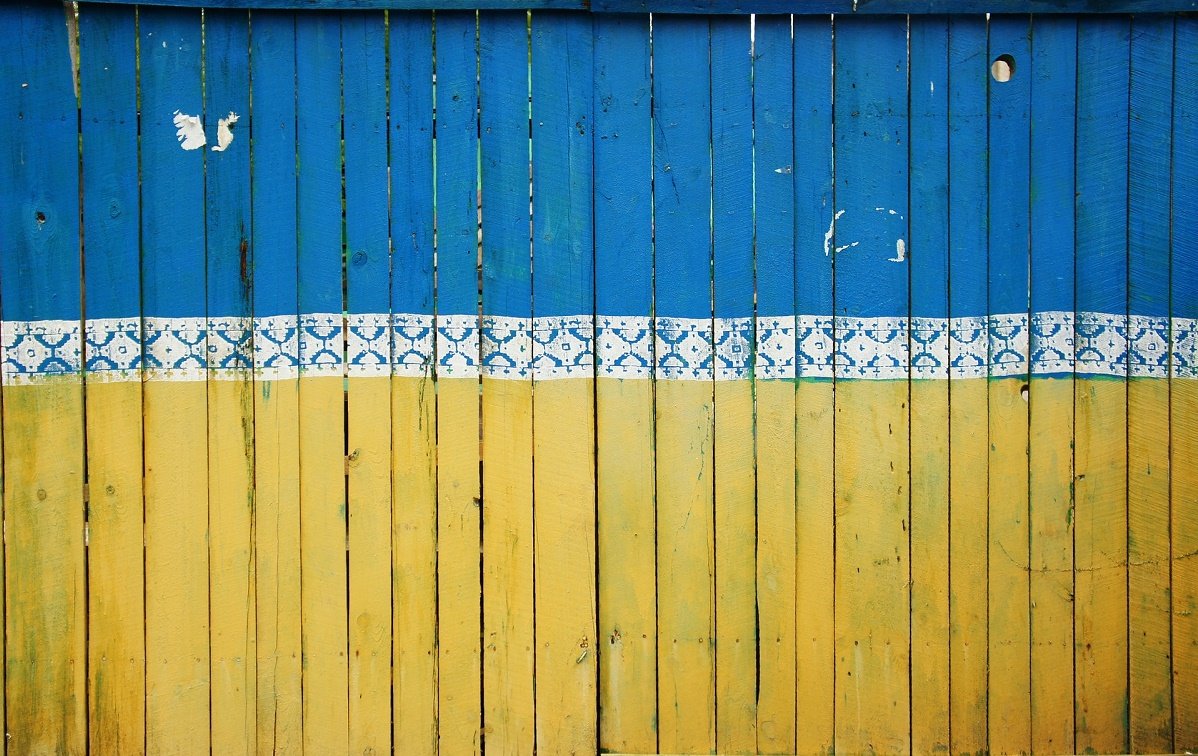 A fence painted in the colours of the Ukranian flag