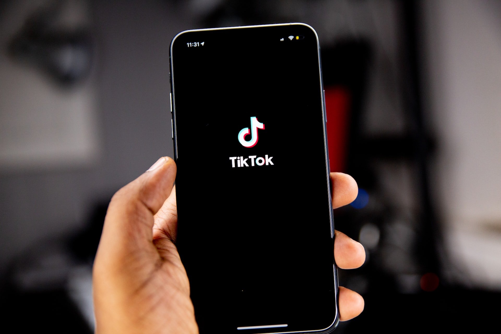 A hand holding an iphone displaying a TikTok interface