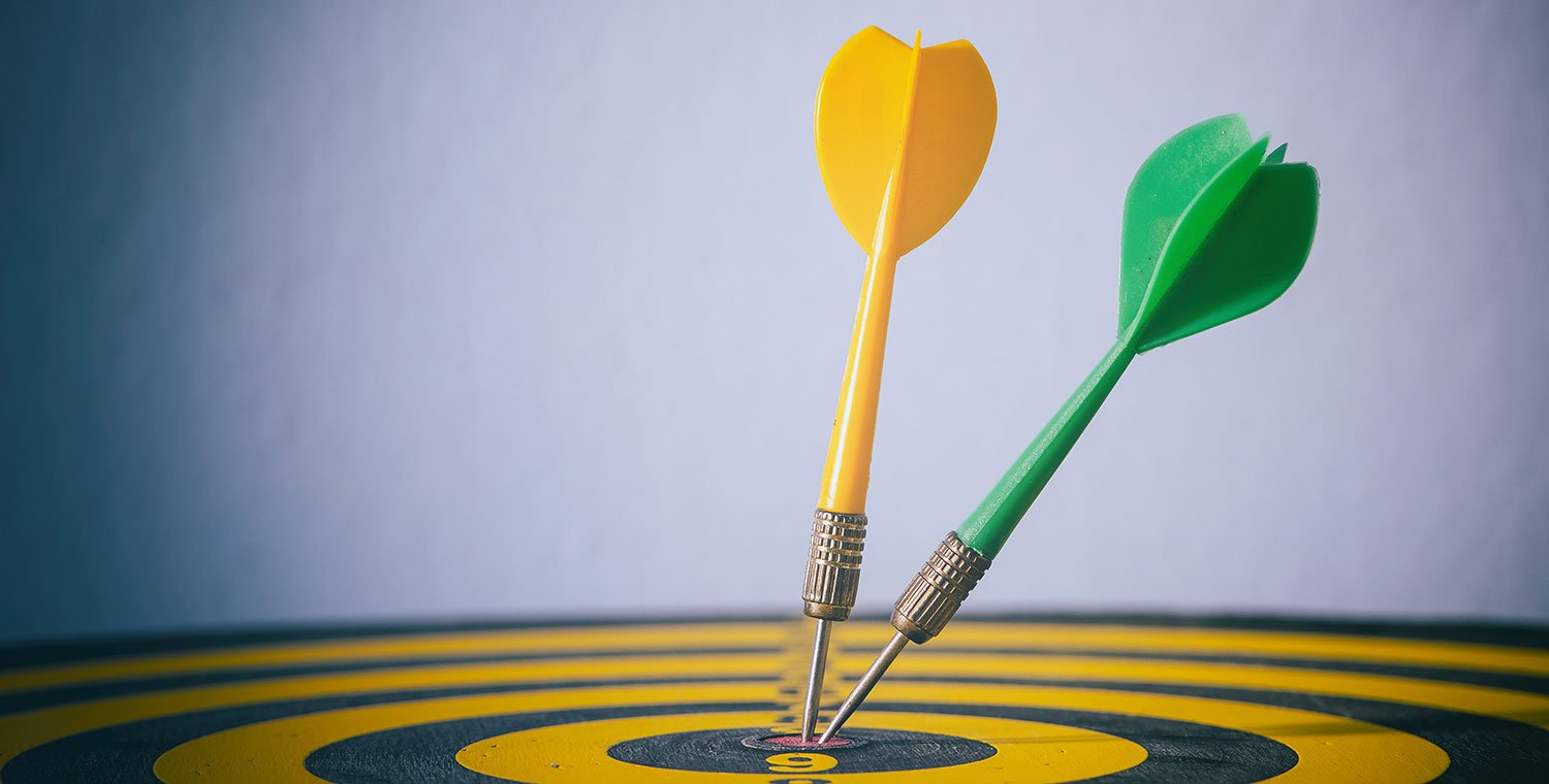 Two darts on the bullseye of a dart board